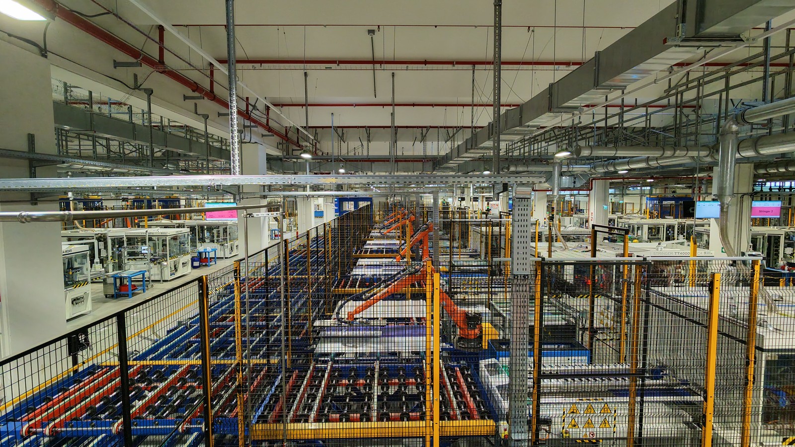 Linha industrial automatizada com braços robóticos e máquinas na 3Sun, em Catania — fotografia ilustrativa